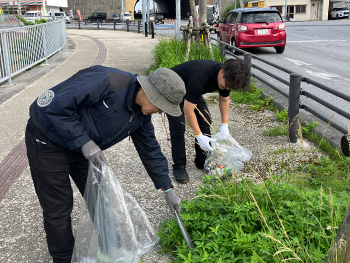 第107回 地域貢献活動で歩道沿いを清掃する様子